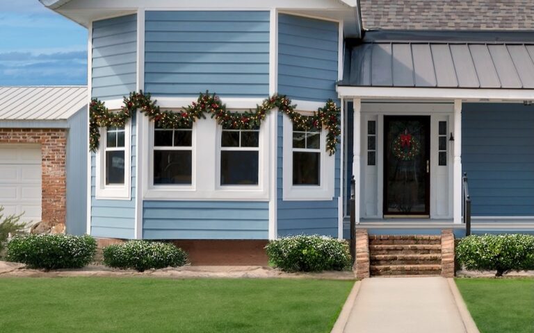 blue house with bay window decorated for the holidays